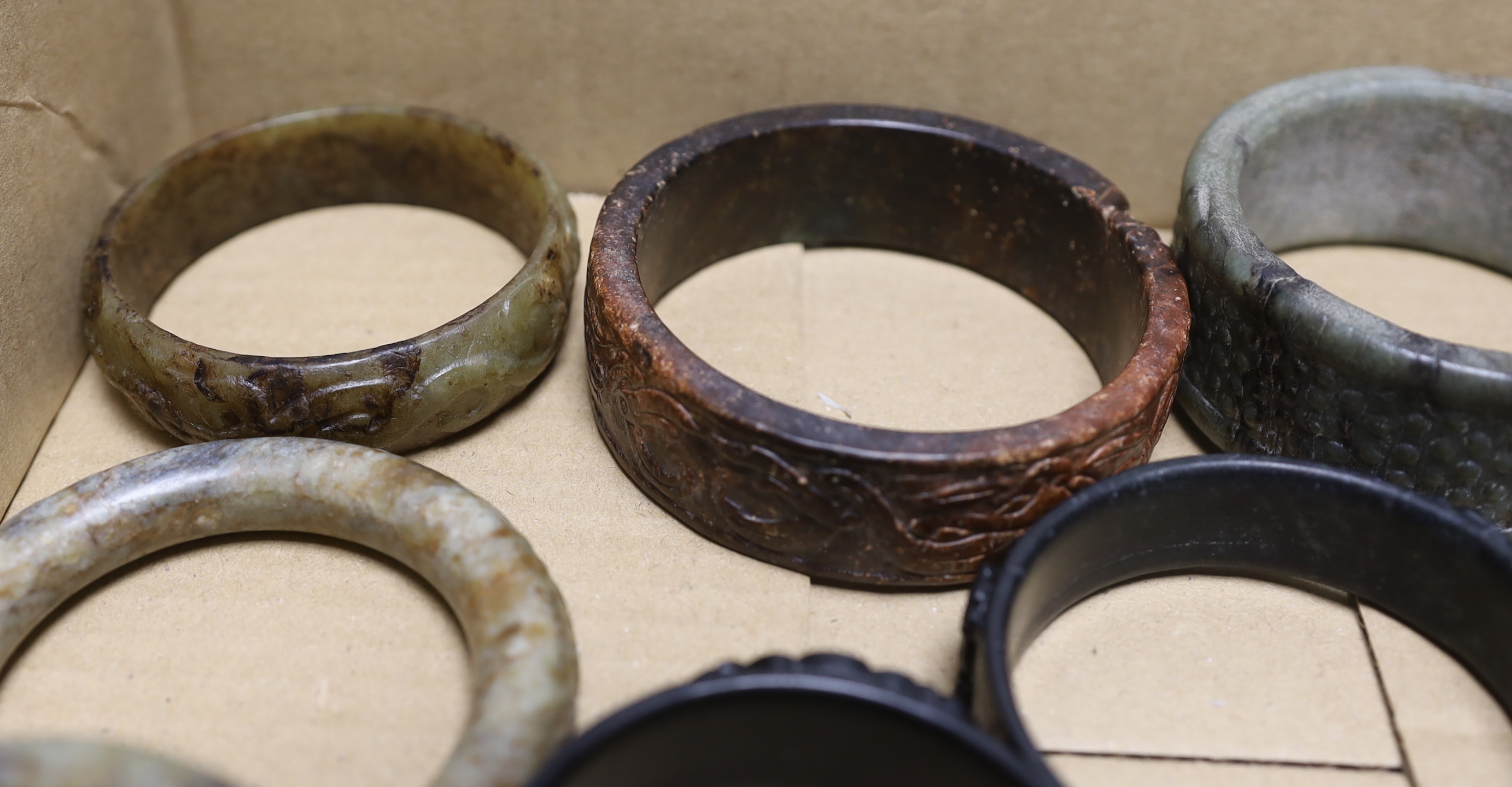 Nine assorted Chinese jade and hardstone bangles and three spheres, largest bangle 8.5cm diameter